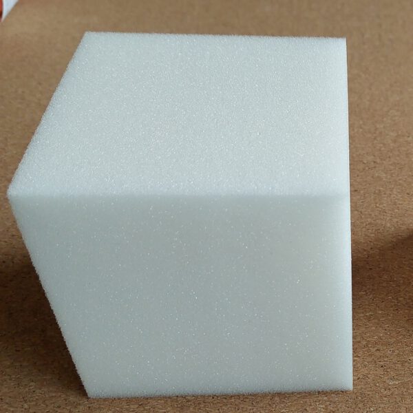 Durable schuimrubber kubus, afmeting 10 x 10 cm. De achtergrond ligt een mat van kurk