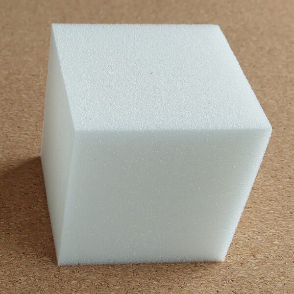 Durable schuimrubber kubus, afmeting 8 x 8 cm. De achtergrond ligt een mat van kurk